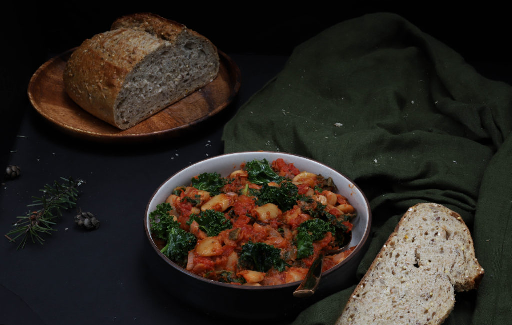 bowl of tomato butter beans with kale and garlic