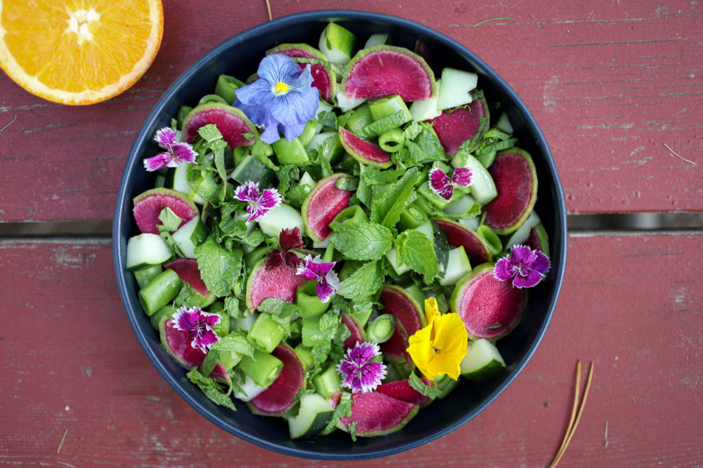 A top down view of sugar snap pea salad on a pink table