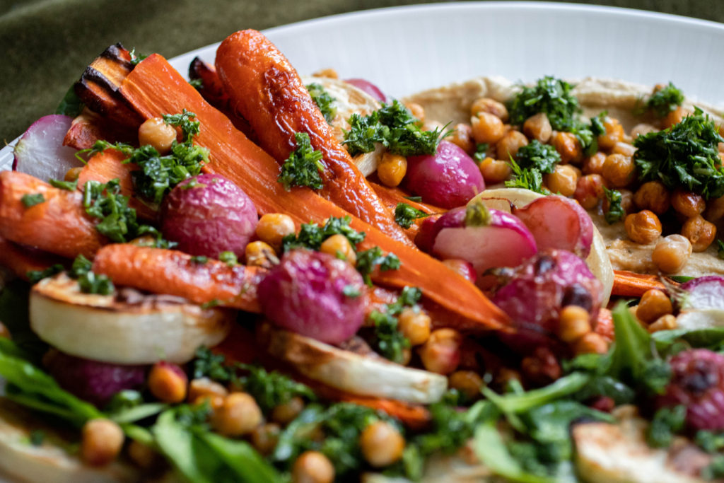 Roasted carrots, radish, and turnips on a hummus salad