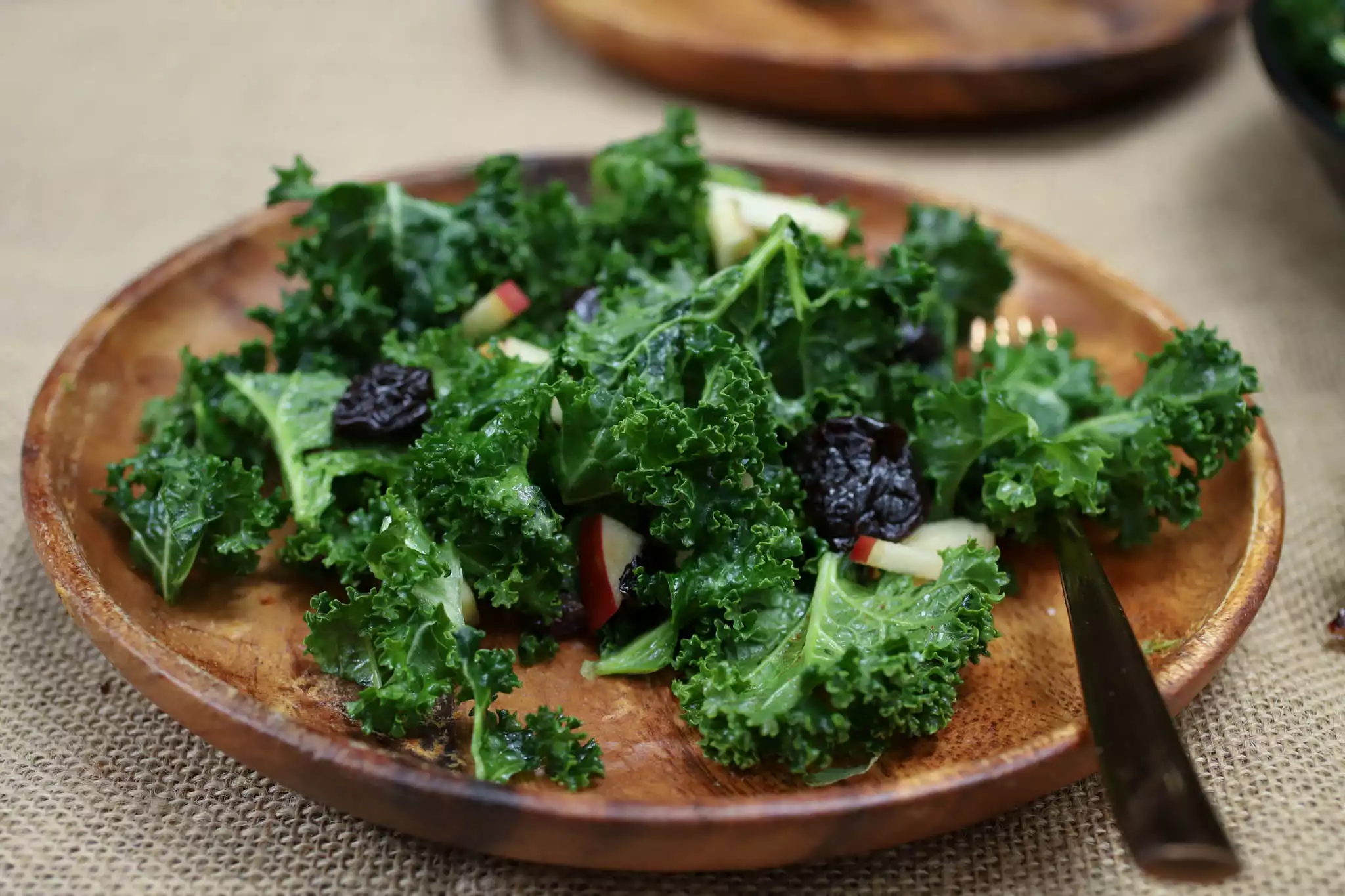 kale salad on a wooden plate