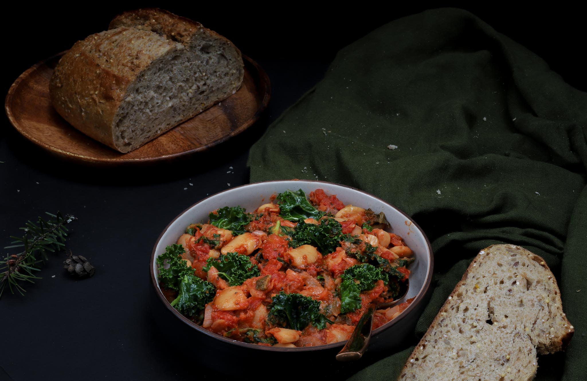 bowl of tomato butter beans with kale and garlic